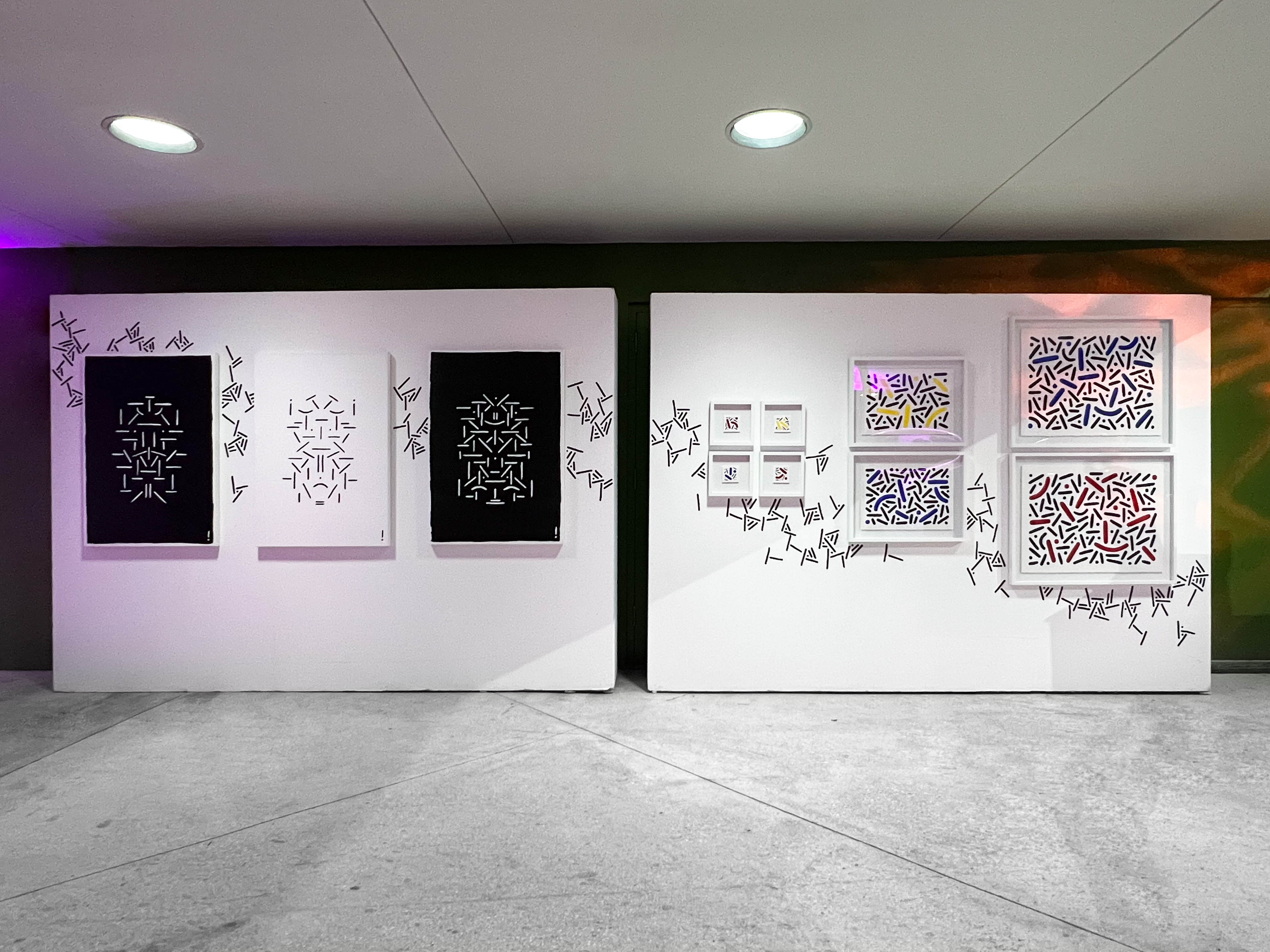 Installation view of Pipe Yanguas’s artworks at Le Art Noir during Miami Art Week 2022, showing black-and-white and colorful geometric compositions surrounded by hand-painted dots and lines added during the artist’s live wall intervention.