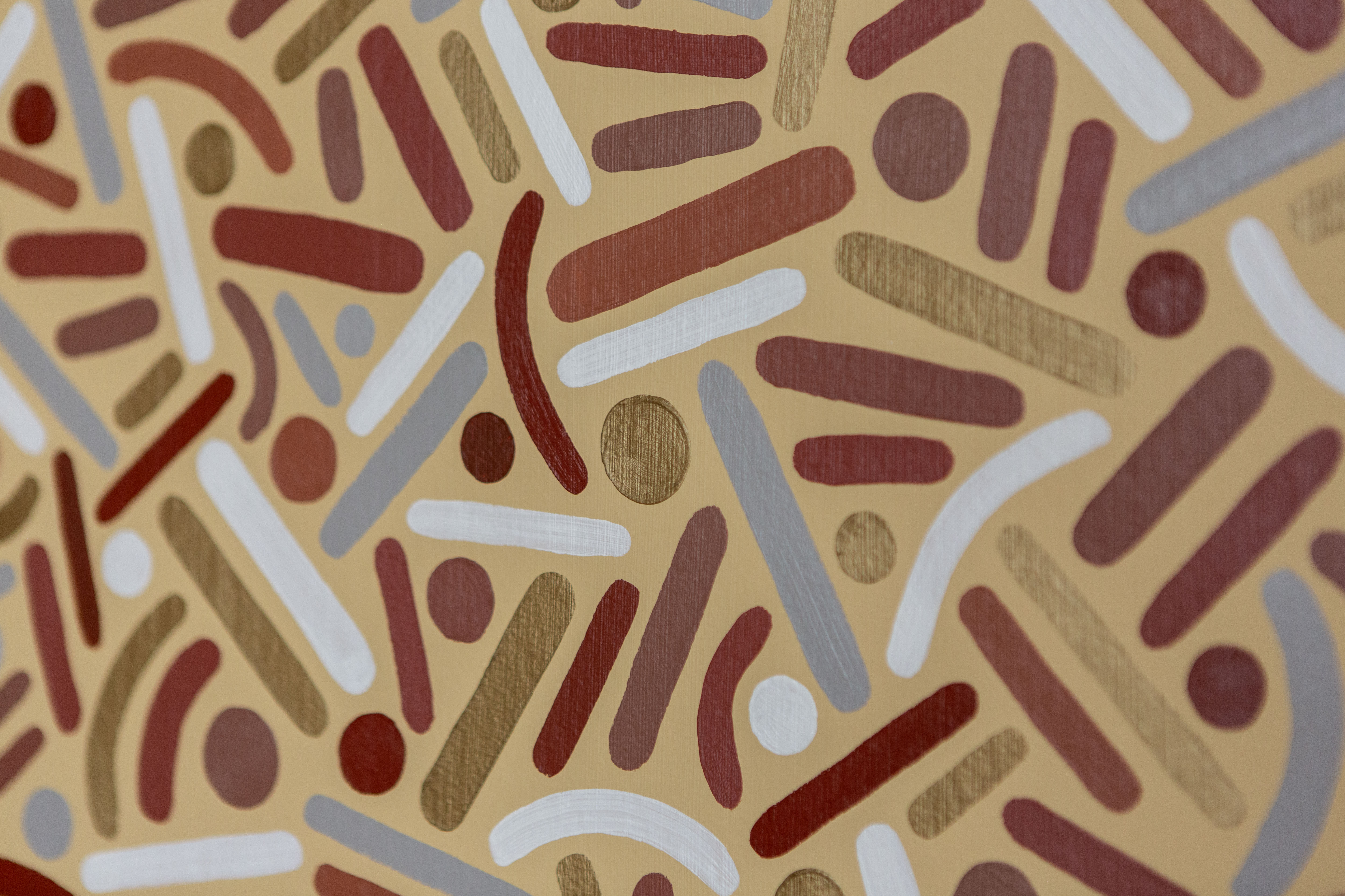 Desert Frequency: Close-up of brown, gold, cream, and pale-blue dots and curves on a light background.