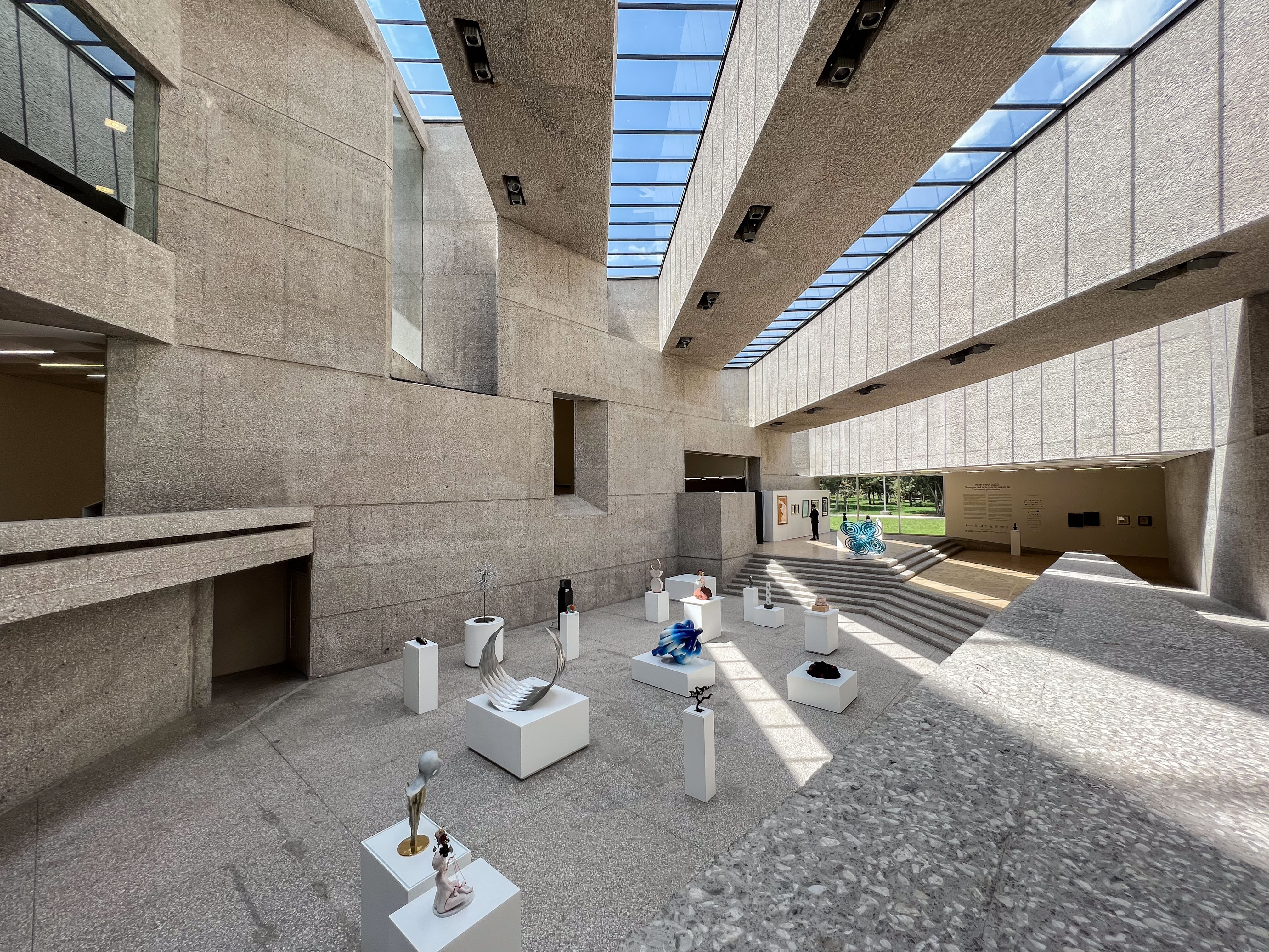 Interior view of Museo Tamayo in Mexico City during Arte Vivo 2022, showing the museum’s monumental concrete architecture, skylights, and contemporary sculptures displayed throughout the exhibition space.