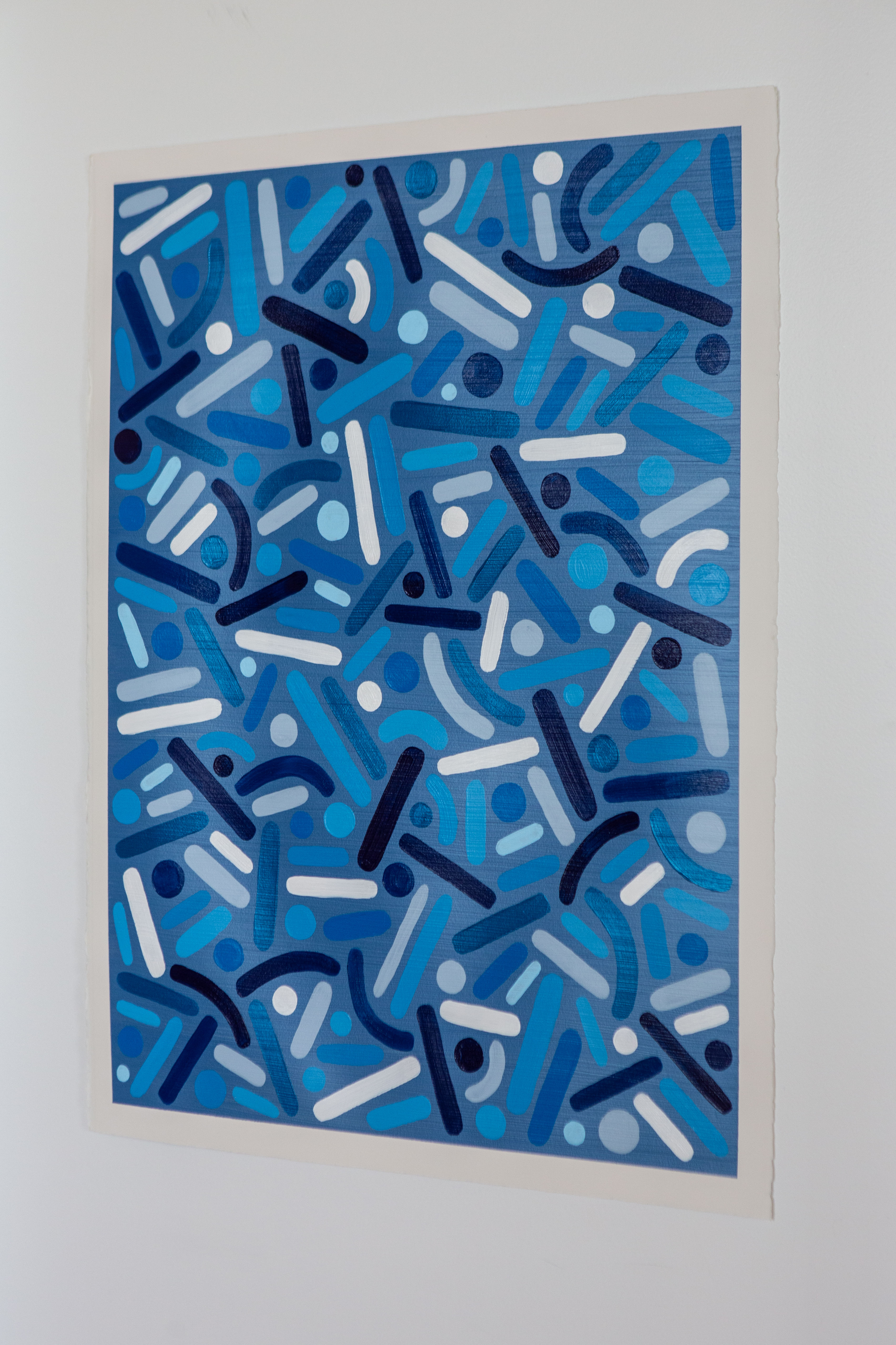 Ocean Frequency: Blue dots-and-curves artwork displayed on a white wall.
