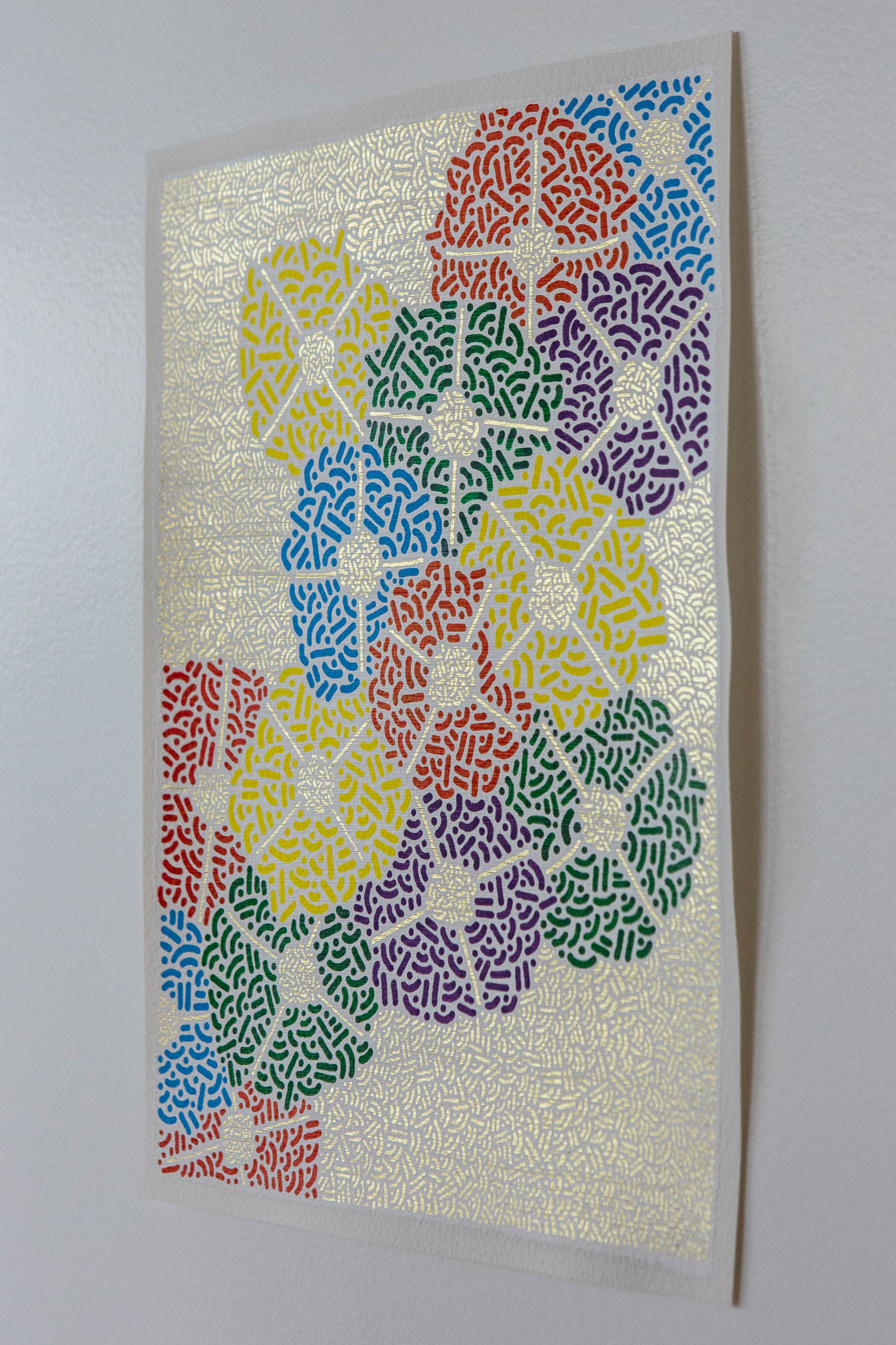 Pollination: Colorful artwork of overlapping patterned circles displayed on a white wall.